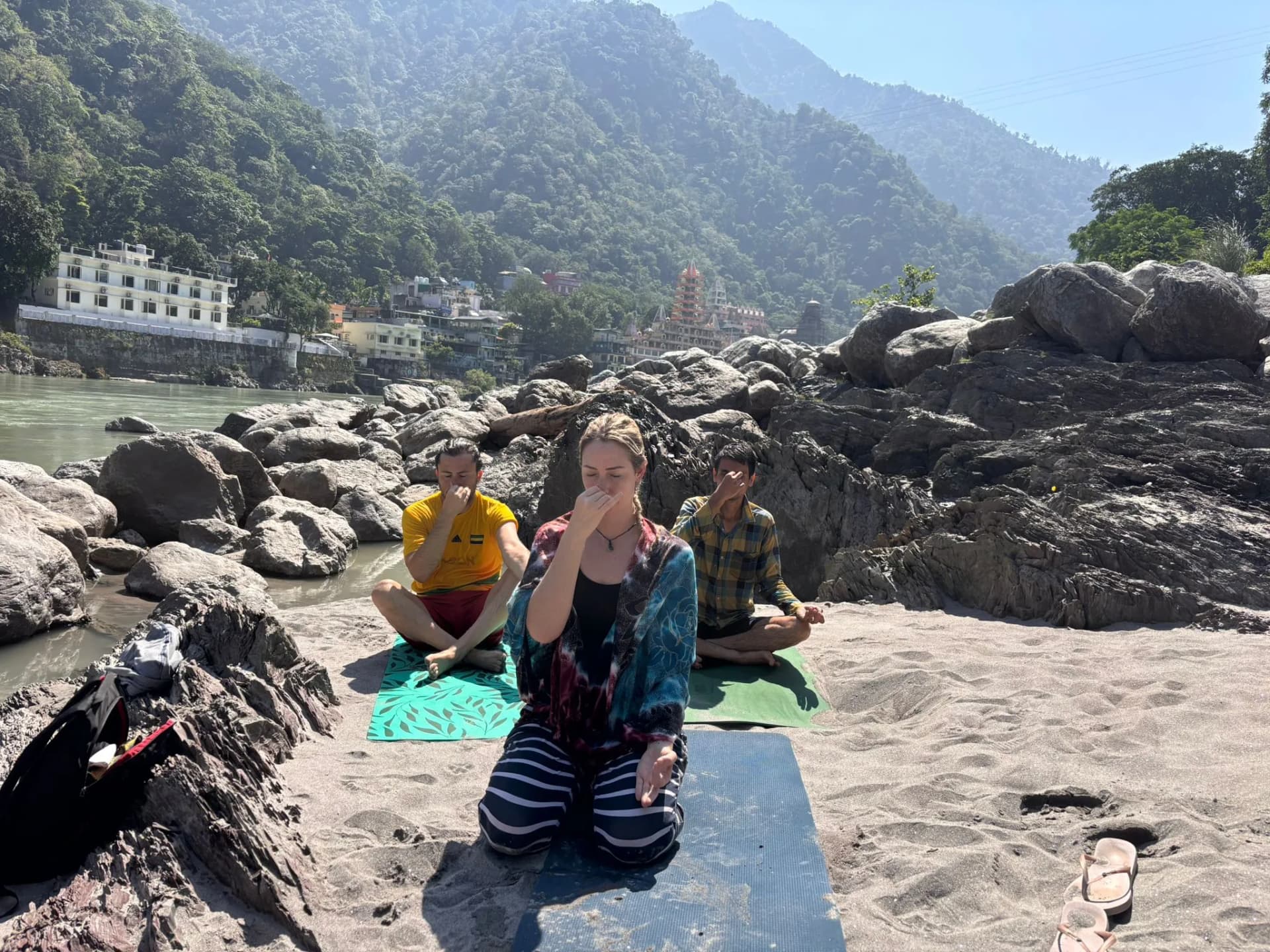Group pranayama retreat participants practicing by the Ganges